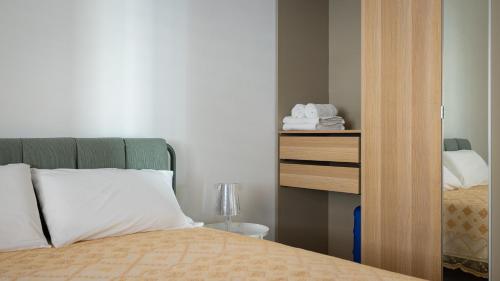 a bedroom with a bed and a dresser with a mirror at Casa BON BON in Triscina