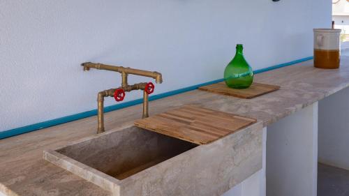 a concrete sink with a green vase on a counter at Casa BON BON in Triscina