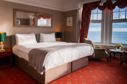 a hotel room with a large bed and windows at Porth Avallen Hotel in St Austell