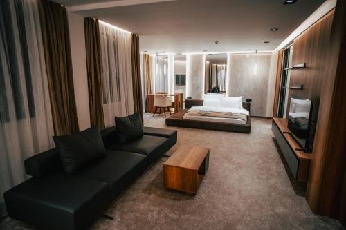 a living room with a couch and a bed at Hotel Bavka in Leskovac