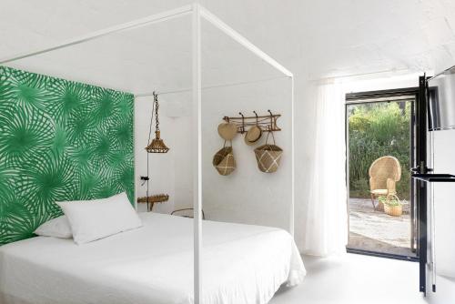 a bedroom with a white bed with a green wall at Cocotrullo in Cisternino