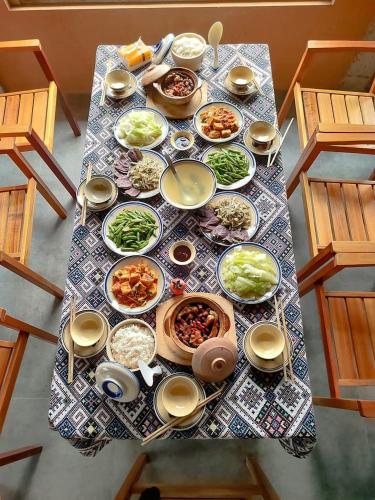 a table with many plates of food on it at Little House in KhauPha, Mu Cang Chai - homestay, cuisine, cafe in Mù Cang Chải