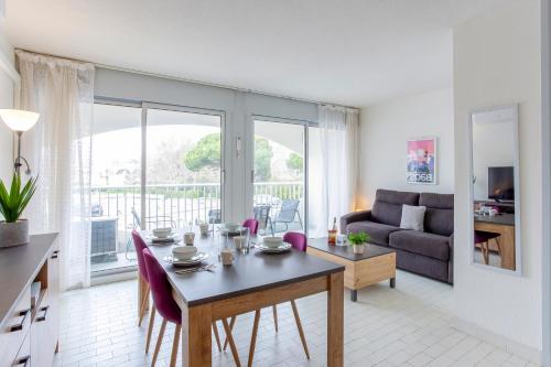 un salon avec une table et un canapé dans l'établissement Chez Édouard 362 - Superbe appartement en première ligne de la plage, à La Grande Motte