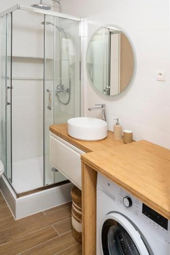 une salle de bain avec un lavabo et une machine à laver dans l'établissement Appartement sur les quais, à Caen
