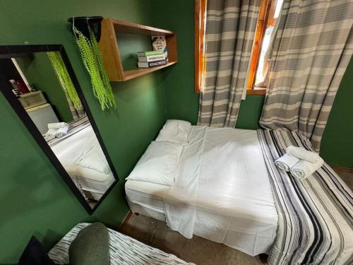 a small bedroom with a bed and a mirror at Flat aconchegante 1 Vila Rica ao lado Mineirão Pampulha BH in Venda Nova