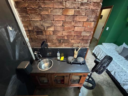 a bathroom with a sink and a brick wall at Flat aconchegante 1 Vila Rica ao lado Mineirão Pampulha BH in Venda Nova