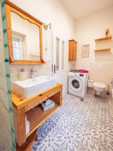 a bathroom with a sink and a washing machine at Ferienwohnung Papenmühle am Kurpark in Bad Freienwalde