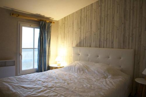 une chambre avec un lit blanc et une fenêtre dans l'établissement Mais 3 pièces 4 couchages SAINT GEORGES D'OLERON SGO000-083, à Saint-Georges-dʼOléron