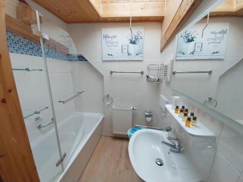 a bathroom with a sink and a shower and a tub at Ferienwohnung - Landhotel Waldschlößchen in Sohland