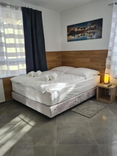 a white bed in a room with a window at WellandHome Aalen - XXL Deluxe Apartment in Aalen
