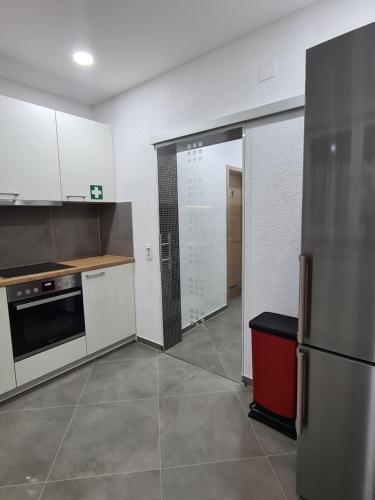 a kitchen with white cabinets and a stainless steel refrigerator at WellandHome Aalen - XXL Deluxe Apartment in Aalen