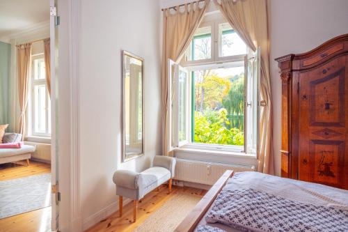 a bedroom with a bed and a large window at Ferienwohnung Papenmühle am Kurpark in Bad Freienwalde