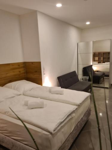 a hotel room with two beds and a chair at WellandHome Aalen - XXL Deluxe Apartment in Aalen