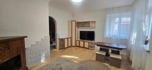 a living room with a tv and a table and a couch at Tract House in Lviv