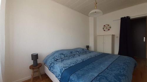 une chambre avec un lit avec une couette bleue dans l'établissement charming apartment, à Stiring-Wendel