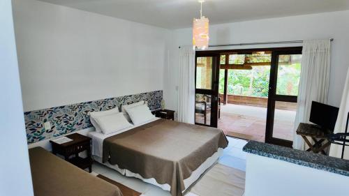 マラウにあるFlat Ewa Condomínio beira-mar Varanda Piscinaのベッドとガラスの引き戸のある寝室