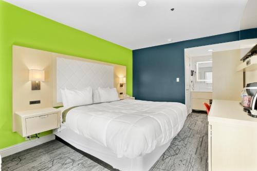 a bedroom with a white bed and a green wall at Signature Inn Berkeley in Berkeley