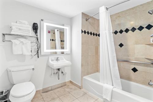 a bathroom with a toilet and a sink and a shower at Signature Inn Berkeley in Berkeley
