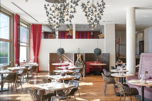 a dining room with tables and chairs and windows at Scarlet Hotel - Adults Only in Mawgan Porth