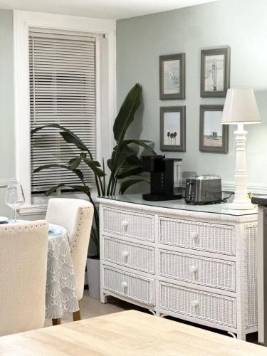 a white dresser in a living room with a plant at The Underwood-Hale House in Providence