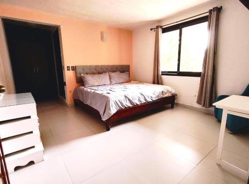 a bedroom with a bed and a window in it at Hotel Jardines del Carmen in San Cristóbal de Las Casas