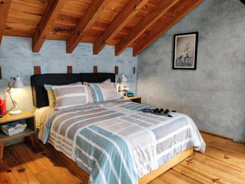 a bedroom with a large bed in a room with wooden ceilings at Hotel Jardines del Carmen in San Cristóbal de Las Casas