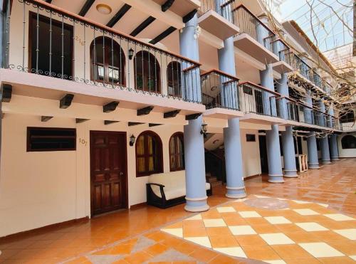 a building with blue columns and a tiled floor at Hotel Jardines del Carmen in San Cristóbal de Las Casas
