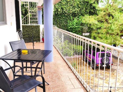 a black table and chairs on a porch with a purple car at Hotel Jardines del Carmen in San Cristóbal de Las Casas
