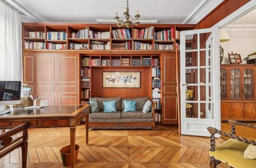 un salon avec des étagères en bois et un canapé dans l'établissement A prestigious location in paris, à Paris