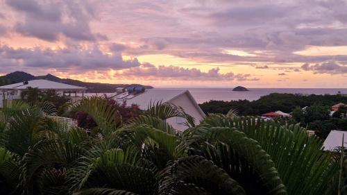 a view of the ocean from a resort at sunset at F2 infinity acces plage a pieds vue mer in La Trinité