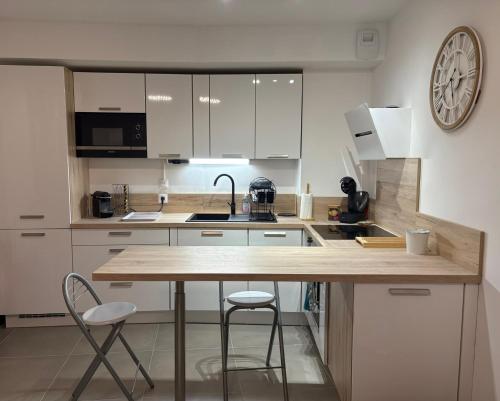 a kitchen with white cabinets and a wooden counter top at Appartement climatisé avec jardin 4 personnes in Plan-de-la-Tour