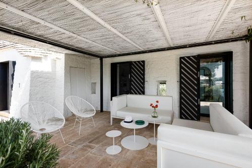 a living room with a white couch and chairs at Cocotrullo in Cisternino