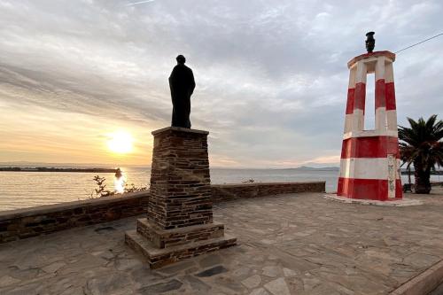 a statue of a man standing next to a lighthouse at Appartamento fronte mare nel cuore di Stintino in Stintino