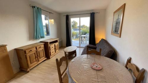 a kitchen with a table and a dining room at Gîte du bosquet in Égletons