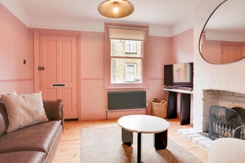 a living room with a couch and a fireplace at Luxury Two Bedroom Cottage - Bishops Stortford in Bishops Stortford