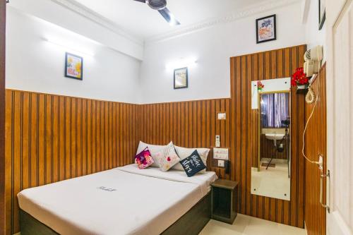 a bedroom with a bed with a wooden wall at Blue Bell Hotel in Nedumbassery