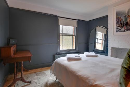 a blue bedroom with a bed and a piano at Luxury Two Bedroom Cottage - Bishops Stortford in Bishops Stortford