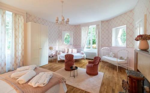 - une chambre avec un lit, 2 chaises et un lit bébé dans l'établissement Villa spacieuse avec piscine à Saint-Gence, à Saint-Gence