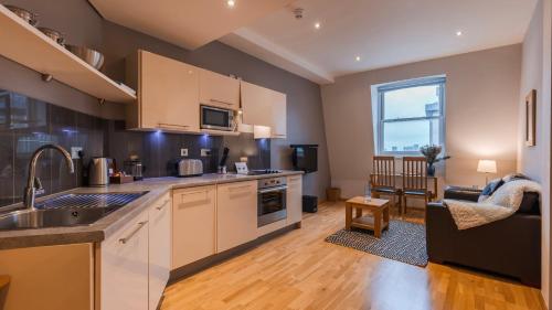 a kitchen with a sink and a counter top at Cannon Street Serviced Apartments by LovelyStay in London