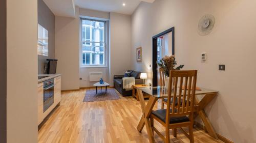a living room with a table and a dining room at Cannon Street Serviced Apartments by LovelyStay in London