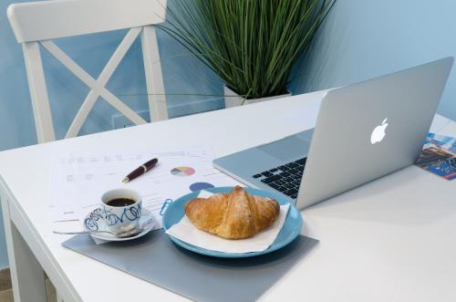 een bord brood, een kop koffie en een laptop bij Casa della Perla, Parcheggio disponibile, centrale in Giarre