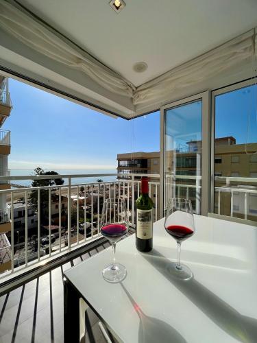 two glasses of wine sitting on a table on a balcony at El Horizonte de Benicassim III, Descubre esta lujosa propiedad a los pies del Mediterraneo in Benicàssim