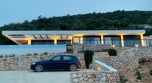 a blue car parked in front of a house at Villa Luxe in Sivota