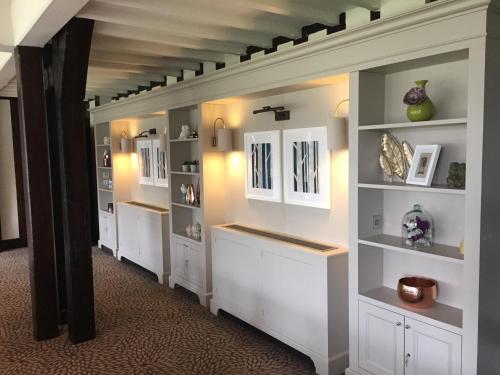 a hallway with white shelves in a room at Hogarths Stone Manor in Kidderminster