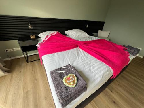 a bed with a pink blanket on top of it at Bett4-you Pinneberg - Prisdorf in Prisdorf