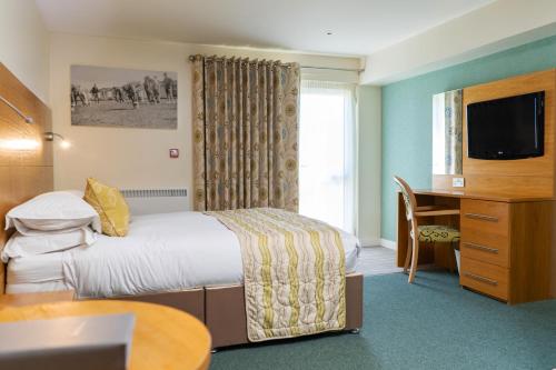 a hotel room with a bed and a desk at Croyde Bay Hotel or Self Catering in Croyde