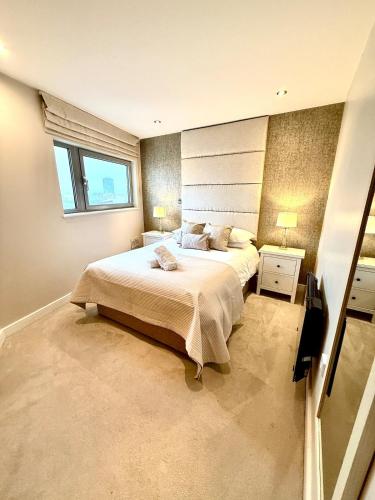 a bedroom with a large bed and a window at Luxe Cardiff Centre Apartment Free Parking in Cardiff
