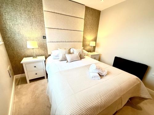 a bedroom with two beds with towels on the bed at Luxe Cardiff Centre Apartment Free Parking in Cardiff