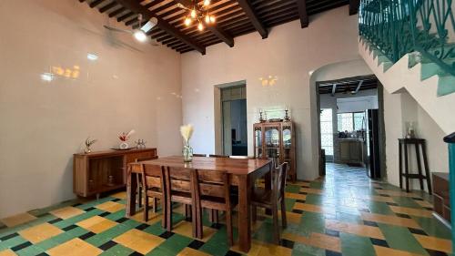 a dining room with a table and chairs on a colorful floor at Casa Esperanza in Campeche