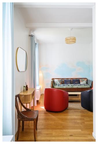 - un salon avec un pouf rouge et un lit dans l'établissement Maison d artiste proche de Paris, à Alfortville